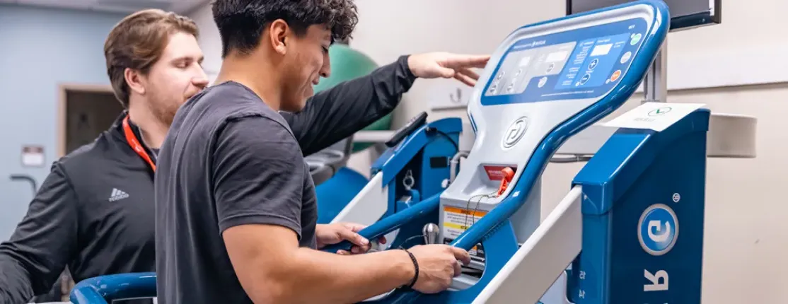 A previous D P T student assists a patient to walk on an anti-gravity treadmill at Maine Medical Center